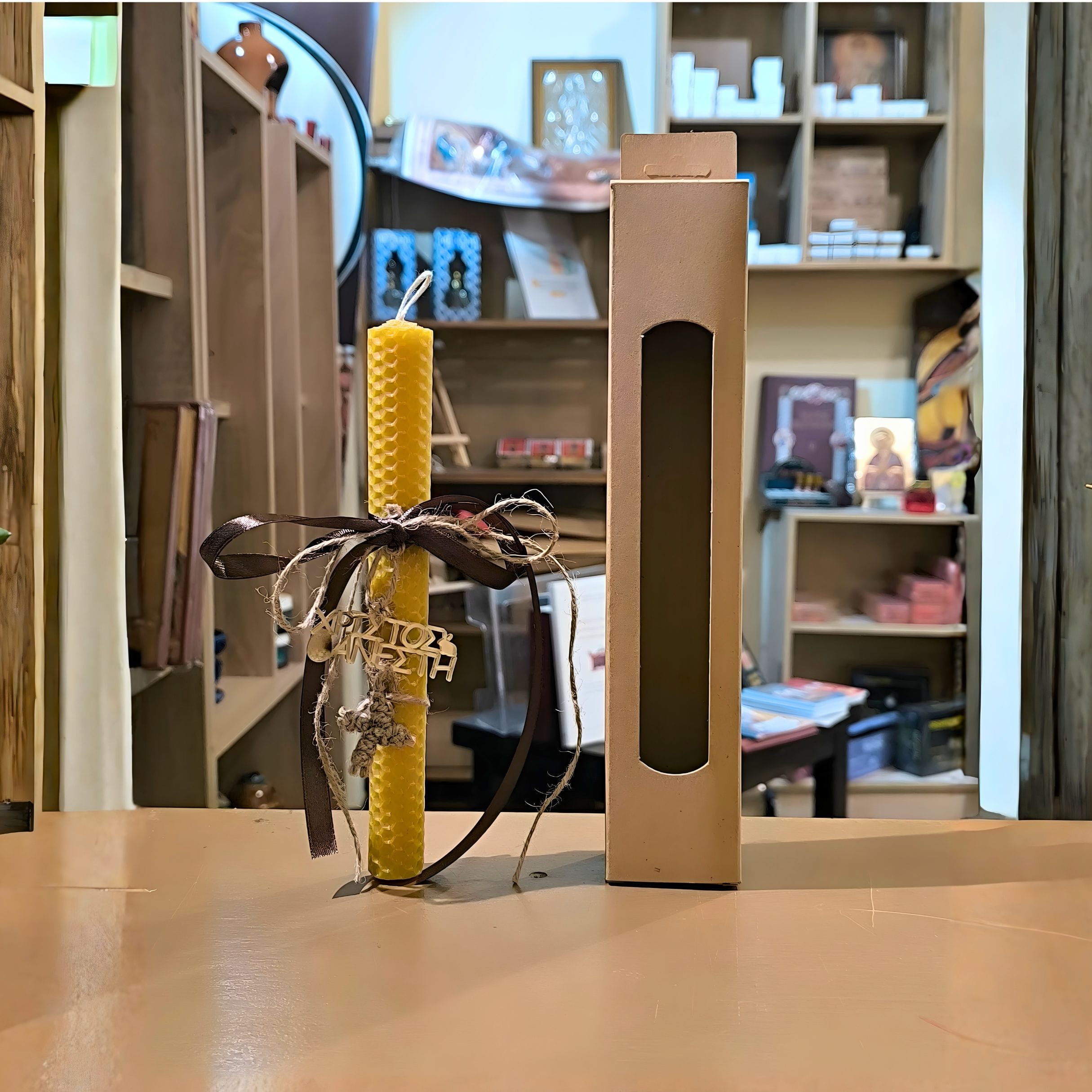 Roku darbs Lieldienu svece, kas izgatavota no dabīgām šūnām, ar brūnu lentīti, adītu krustu un dāvanu kastīti.